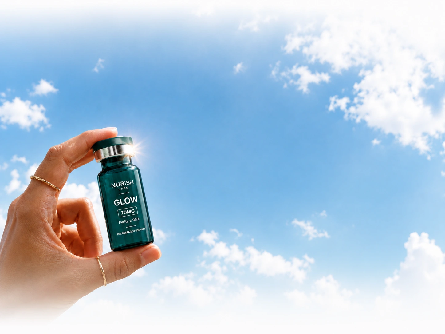 Hand holding a NURISH LABS GLOW vial against a blue sky